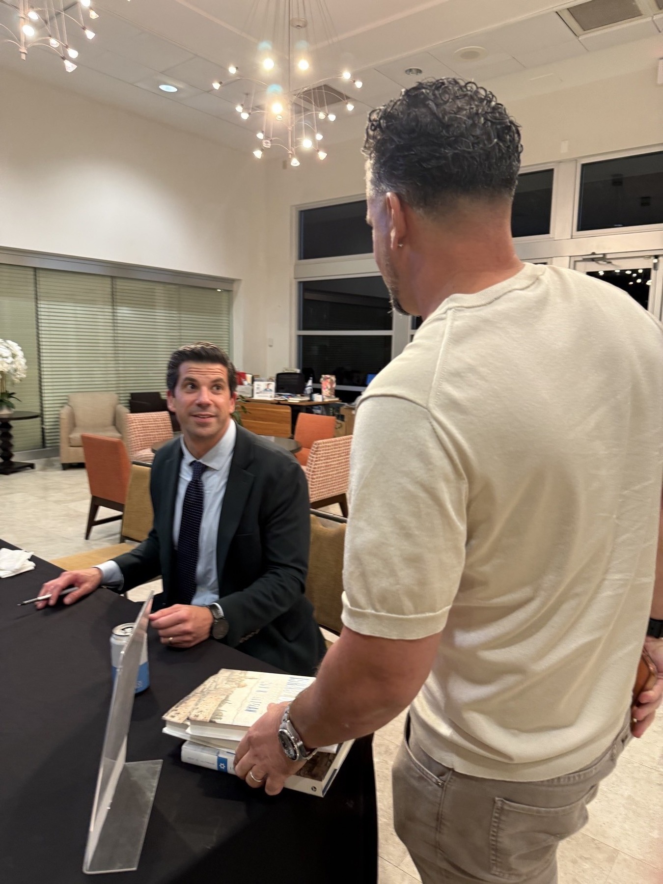 At the signing table. The book is Israel on Trial. The man who wrote it is Roy K. Altman.