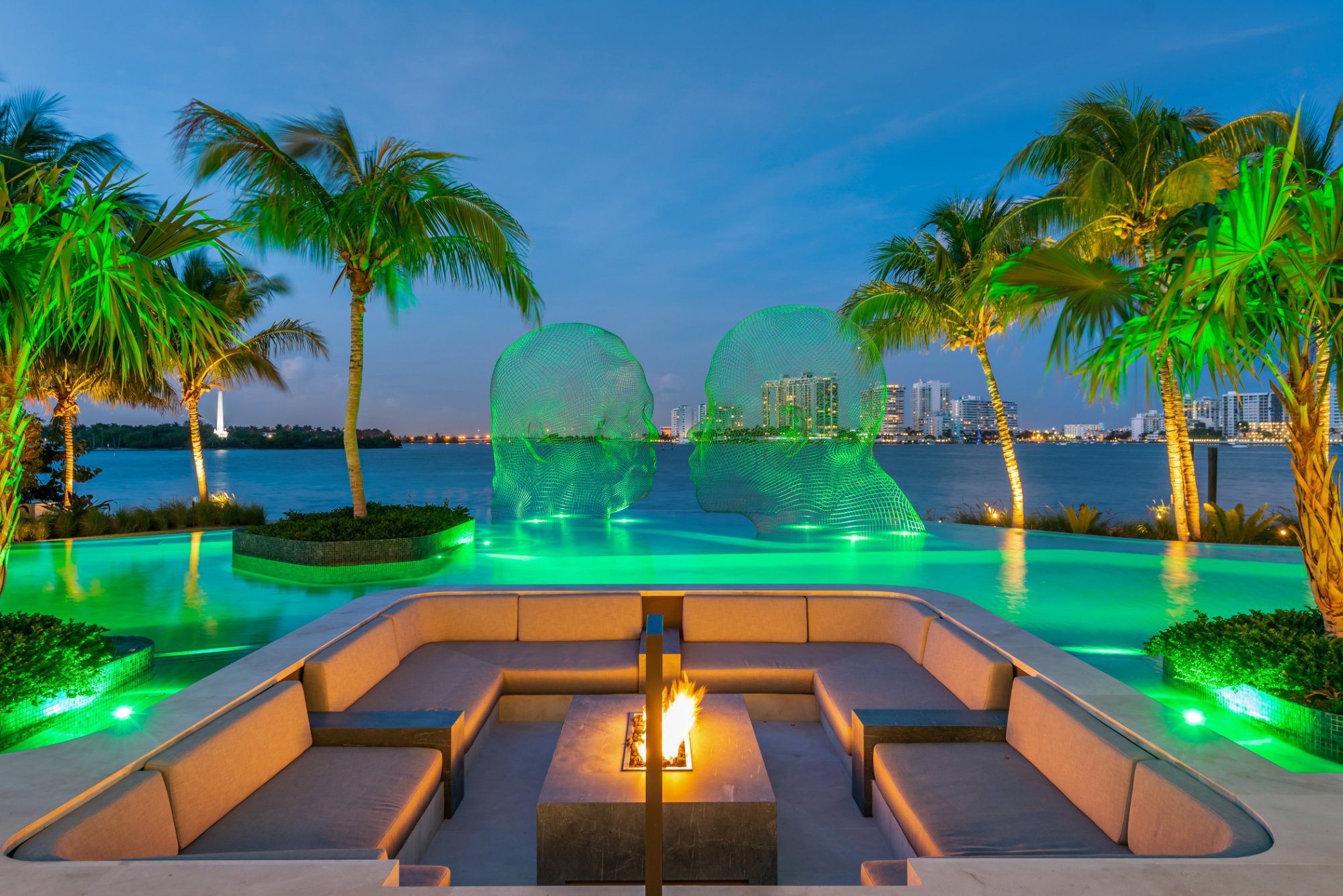 The sunken fire pit and infinity-edge pool, flanked by sculptures from world-renowned artist Jaume Plensa — the visionary behind Chicago's Crown Fountain in Millennium Park.