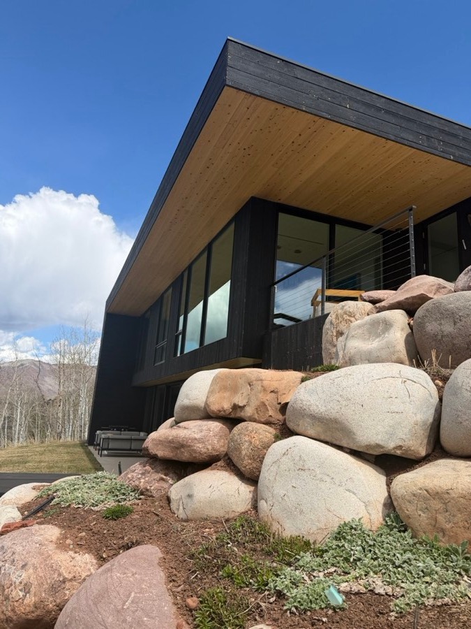 Stone luxury home framed by aspens