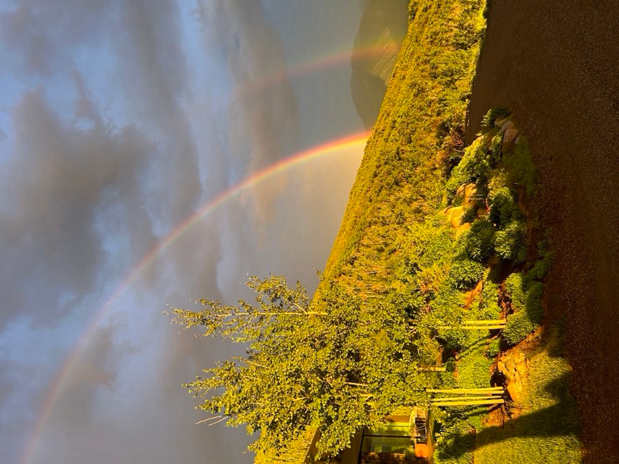 Double rainbow over Aspen valley with forested hillside