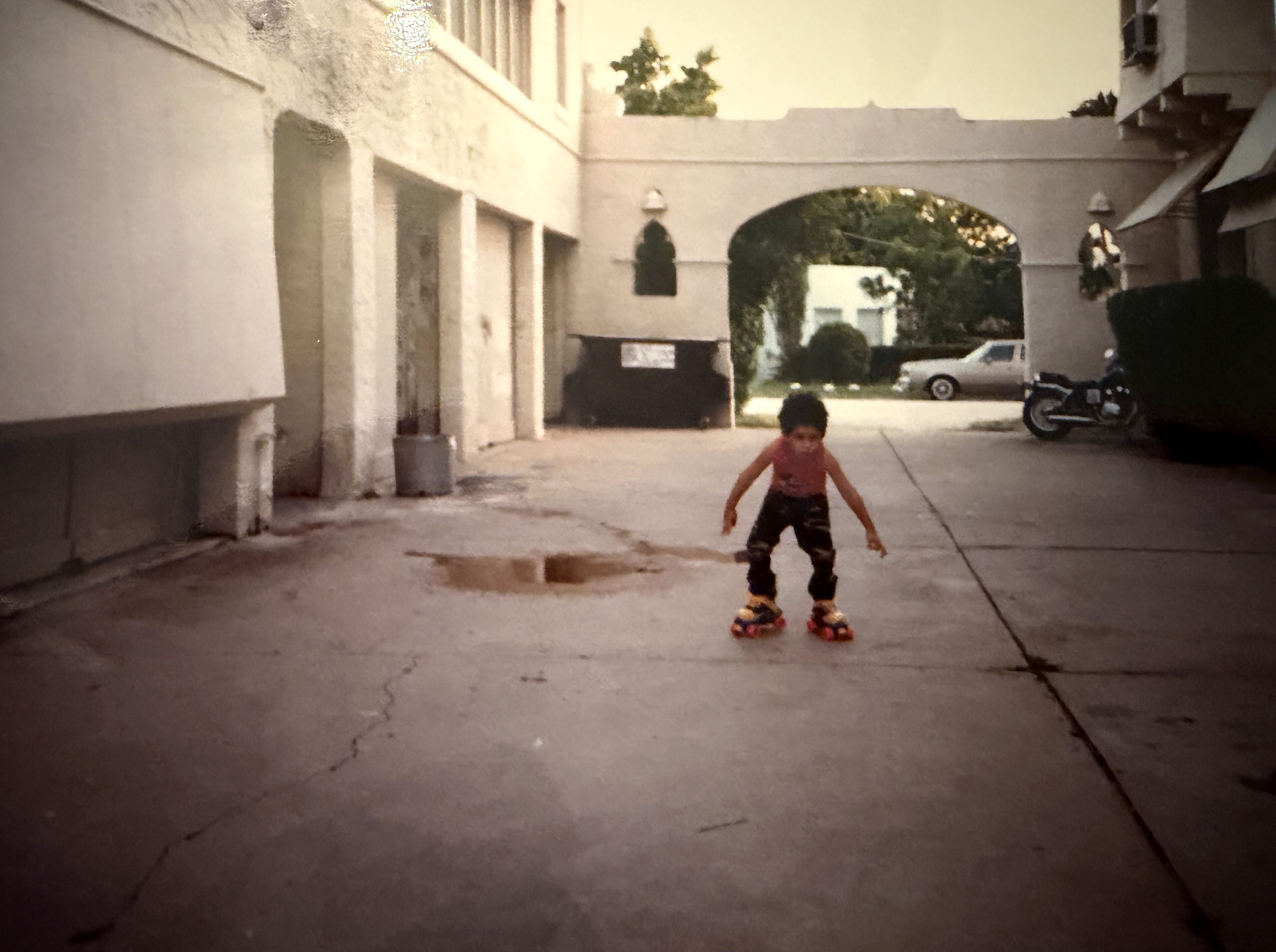 Same courtyard, late 1980s. Same archway, same brick path, same building. Me, attempting to rollerskate.