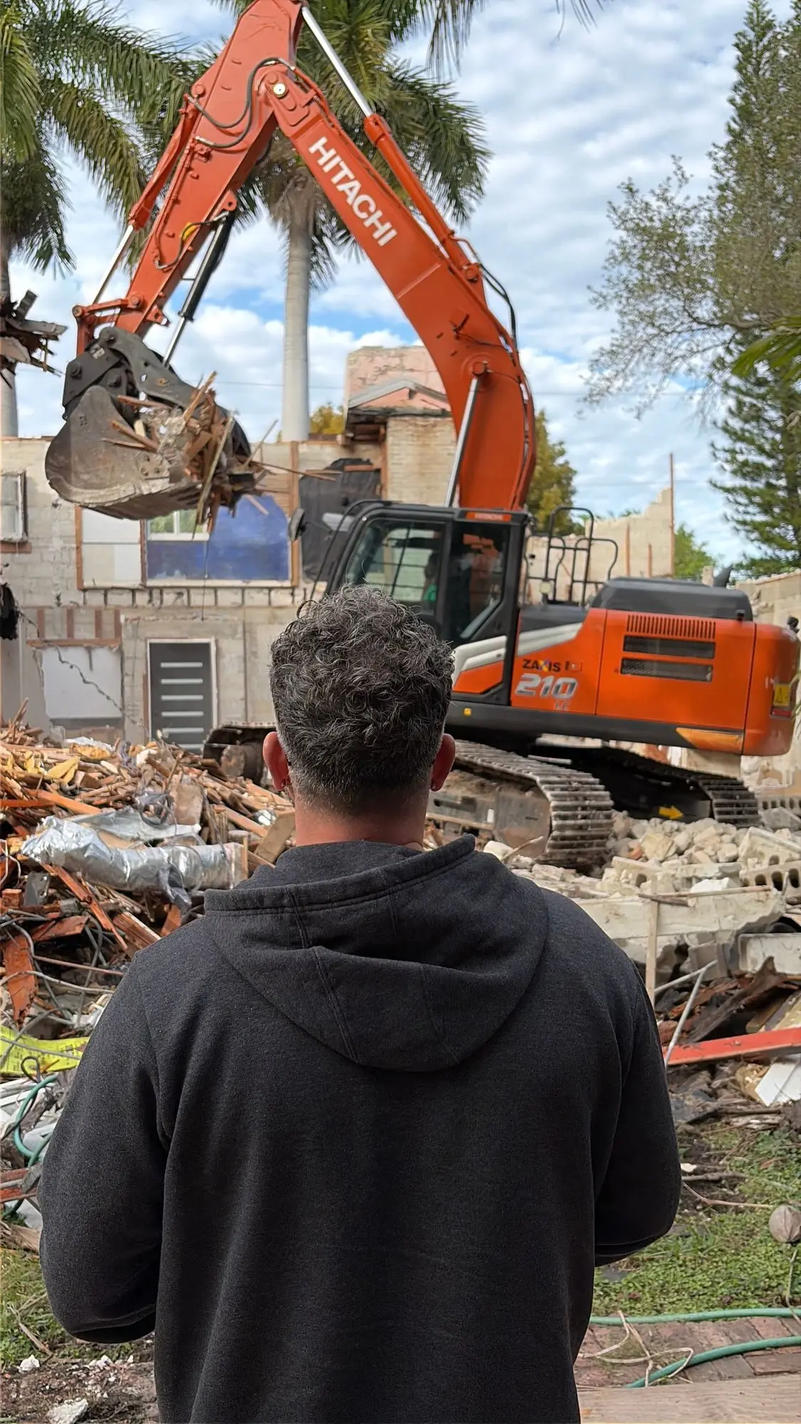 Watching the old house come down — every swing of the excavator was deliberate.