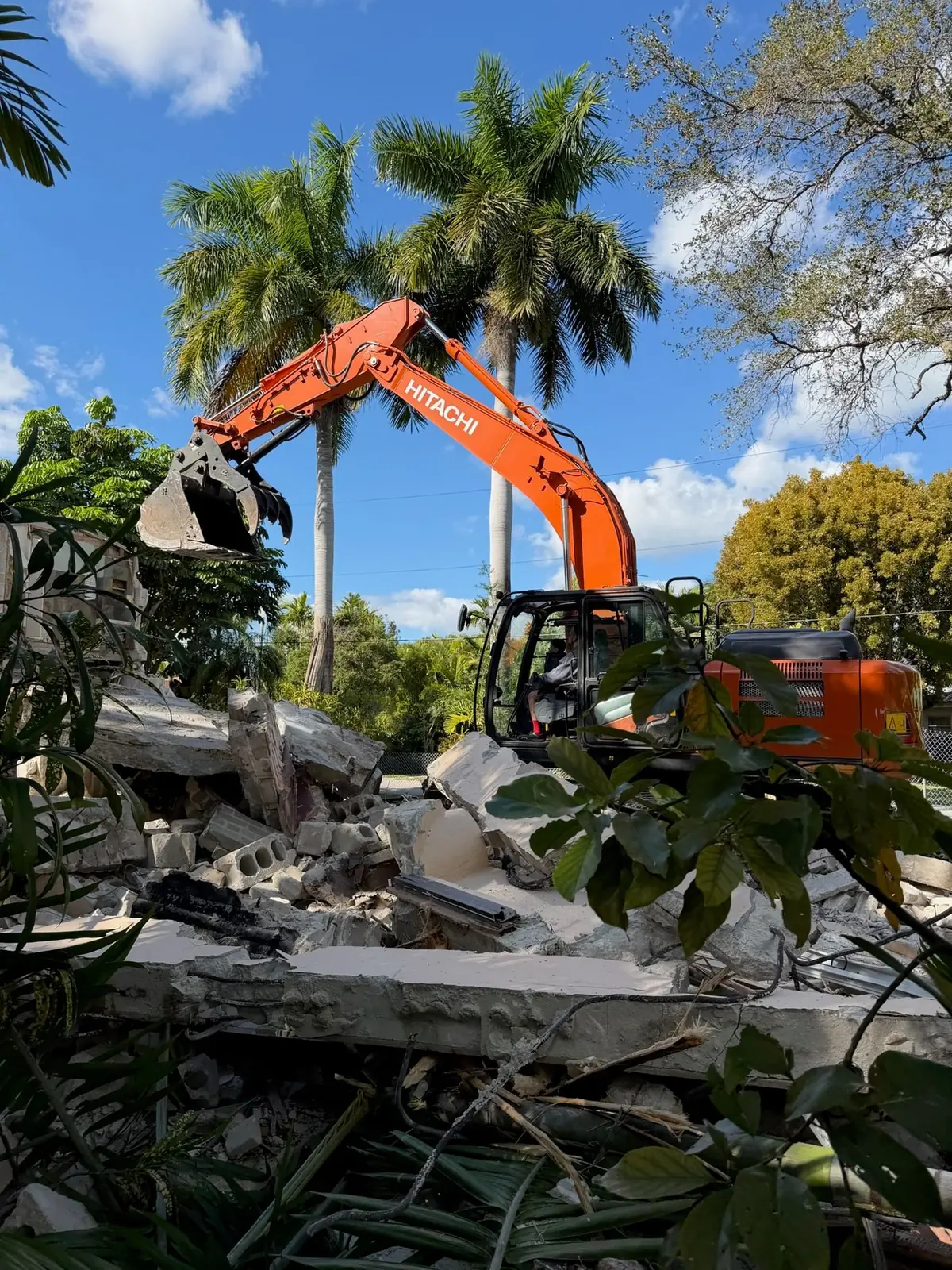 The Hitachi at work — tearing through nearly a century of concrete and memory.