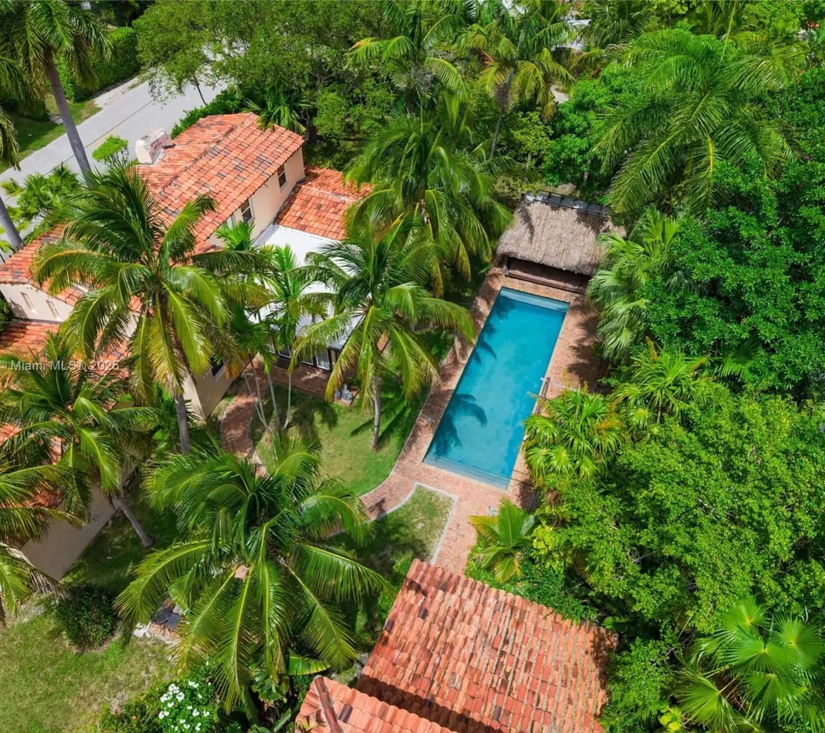 The original 1933 house from above — terra cotta roofs, tiki hut, and a layout from another era.